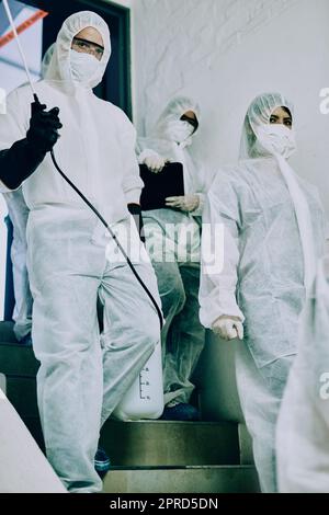 Das Dream Virus Fighting Team. Eine Gruppe von Mitarbeitern im Gesundheitswesen, die Hazmat-Anzüge tragen, arbeitet zusammen, um einen Ausbruch zu kontrollieren. Stockfoto