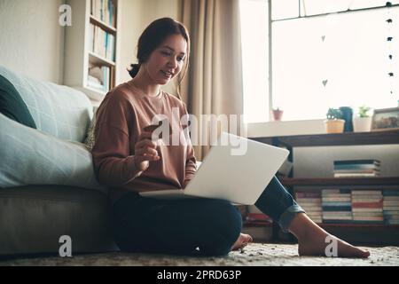 Endlich kann ich die erste in der Kasse Zeile. Eine junge Frau mit einem Laptop und Kreditkarte zu Hause. Stockfoto