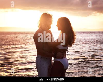 Ich verirrte mich in deinen Augen und verirrte mich in deinem Lächeln. Ein liebevolles junges Paar, das gemeinsam am Strand viel Zeit verbringt. Stockfoto