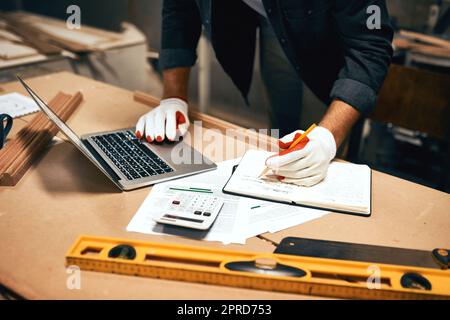 Alle in einem Tag arbeiten als Tischler. Ein unkenntlich männlicher Tischler, der nachts in einer Werkstatt arbeitet. Stockfoto