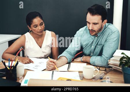 Gemeinsam bilden sie ein tolles Team. Zwei junge Architekten arbeiten in einem modernen Büro zusammen. Stockfoto