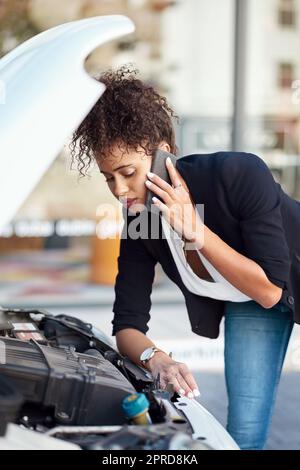 Das kann sie nicht allein beheben: Eine attraktive junge Geschäftsfrau, die Pannenhilfe anruft, nachdem ihr Auto ausgefallen ist. Stockfoto