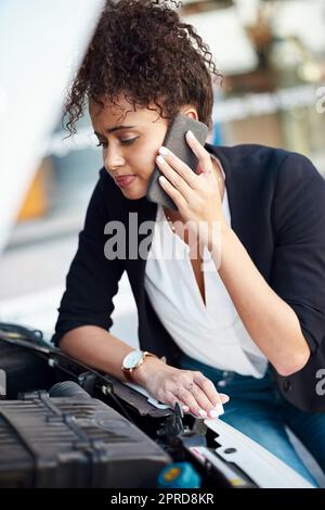 Es sieht so aus, als ob shes ein wenig darauf warten würde. Eine attraktive junge Geschäftsfrau rief am Straßenrand Hilfe an, nachdem ihr Auto ausgefallen war. Stockfoto