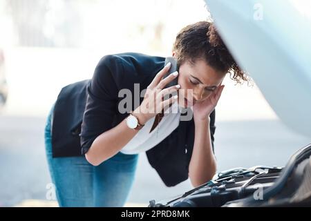 Ich brauche hier sofort jemanden. Eine attraktive junge Geschäftsfrau, die Pannenhilfe anruft, nachdem ihr Auto ausgefallen ist. Stockfoto