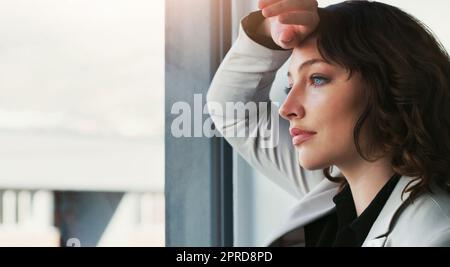 Die Arbeit war noch nie so unangenehm, eine attraktive junge Geschäftsfrau, die sich bei der Arbeit deprimiert fühlt. Stockfoto