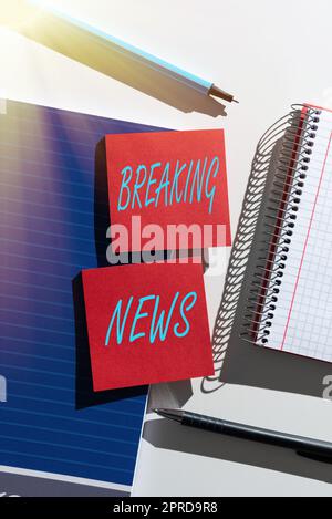 Textzeichen mit aktuellen Nachrichten. Business Approach Sonderbericht Ankündigung der aktuellen Ausgabe Flashnews wichtige Neuigkeiten präsentiert auf zwei Haftnotizen am Schreibtisch mit Notizbuch und Stiften Stockfoto