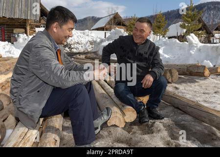 (230427) -- HEMU, 27. April 2023 (Xinhua) -- Suka (L) erzählt einem Dorfbewohner von den Regeln für die Hausrenovierung im Dorf Hemu in Kanas, Nordwestchina der Autonomen Region Xinjiang Uygur, 30. März 2023. HEMU Village liegt am malerischen Ort Kanas am Ausgangspunkt der G219 National Highway. Suka, die Parteisekretärin des Dorfes, führt die Einheimischen auf dem Weg zur ländlichen Neubelebung. Der Beitritt zum Pferdeteam ist eine wichtige Einnahmequelle für die Dorfbewohner. Jedes Mitglied kann zwei Pferde zum Team bringen, um den Service für Touristen bereitzustellen. Zurzeit haben 68 der Teammitglieder zucken Stockfoto