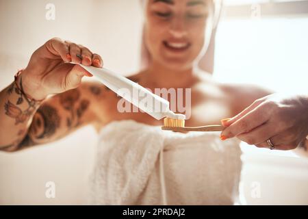 Die richtige Zahnpasta macht den Unterschied. Eine junge Frau putzt sich zu Hause im Badezimmer die Zähne. Stockfoto