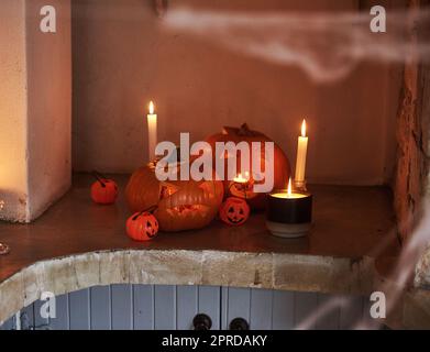 Dies ist ein beängstigender Anblick. Stillleben von geschnitzten Kürbissen und brennenden Kerzen zusammen zur Feier von halloween platziert. Stockfoto