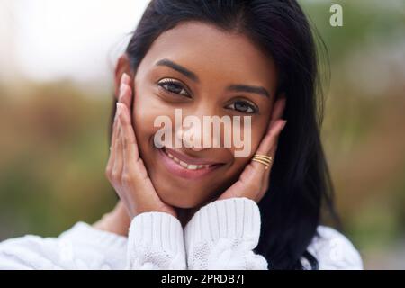 Es gibt so viele schöne Gründe, glücklich zu sein. Eine schöne junge Frau, die draußen steht. Stockfoto