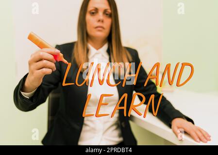 Textunterschrift zur Präsentation von Lunch and Learn. Internetkonzept Haben Sie die Motivation zum Essen und Studium, um zu lernen Essen Geschäftsfrau mit einer Hand Marker halten und wichtige Ideen zeigen. Stockfoto