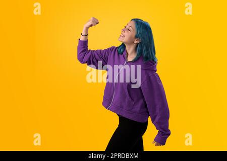 Junger Gilr mit blauem Haar, der eine Siegergeste macht Stockfoto