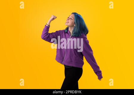 Junger Gilr mit blauem Haar, der eine Siegergeste macht Stockfoto