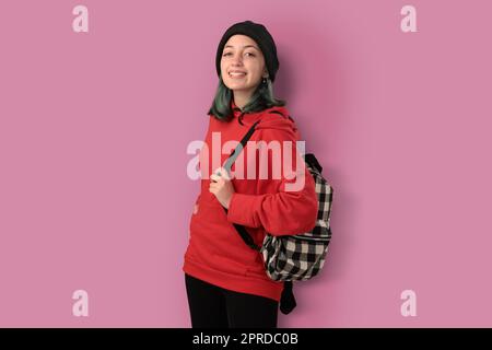 Süßer junger Gilr-Student mit blauen Haaren und einem isolierten Rucksack Stockfoto