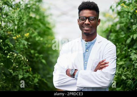 Die nicht gerne unter freiem Himmel arbeiten würden. Porträt eines hübschen jungen Botanikers, der mit seinen Armen im Freien in der Natur posiert. Stockfoto