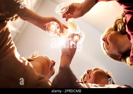 Erheben Sie Ihr Glas, wenn Sie die Hochzeitsglocken hören. Ein kleiner Winkel von einer unbekannten Braut und ihren Brautjungfern, die vor der Hochzeit einen Toast mit Weingläsern in ihrer Garderobe ausbringen. Stockfoto