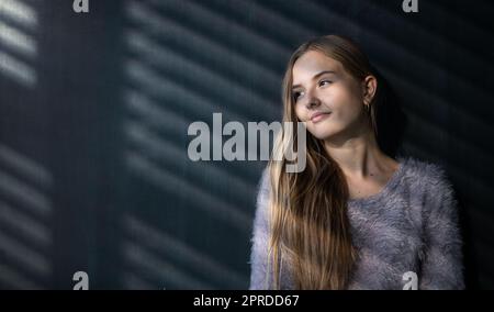 Hübsche, junge Schülerin vor einer Tafel während der Klasse Stockfoto