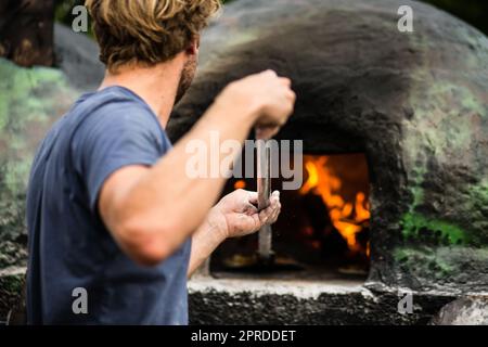 Kochen backen Pizza im traditionellen Holzofen Stockfoto