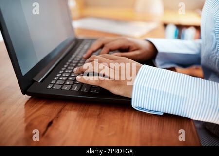 Eine Geschäftsfrau, die einen Laptop an ihrem Schreibtisch benutzt. Stockfoto