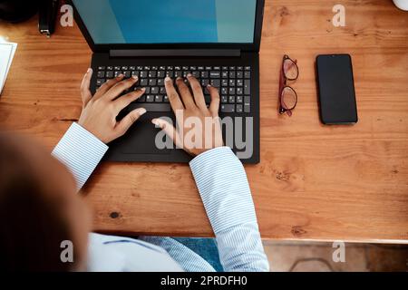 Alle Informationen, die ein Unternehmer braucht, um auf dem neuesten Stand zu bleiben. Eine Geschäftsfrau, die einen Laptop benutzt, während sie von zu Hause aus arbeitet. Stockfoto