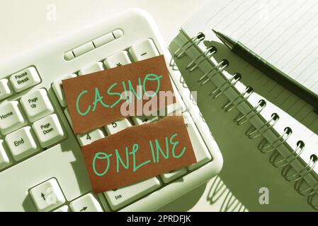 Text wird angezeigt Casino Online. Konzept bedeutet Computer Poker Game Gamble Royal Bet Lotto High Stakes Ripped Note with Important Messages Over Keyboard on Desk with Notebooks. Stockfoto
