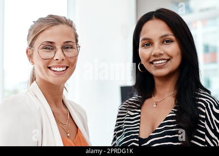 Zwei der besten. Beschnittenes Porträt von zwei attraktiven jungen Geschäftsfrauen, die in ihrem Büro stehen. Stockfoto