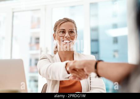 Herzlich Willkommen. eine attraktive junge Geschäftsfrau, die sich bei einem Treffen im Sitzungssaal mit einem unkenntlichen Kollegen die Hände schüttelt. Stockfoto