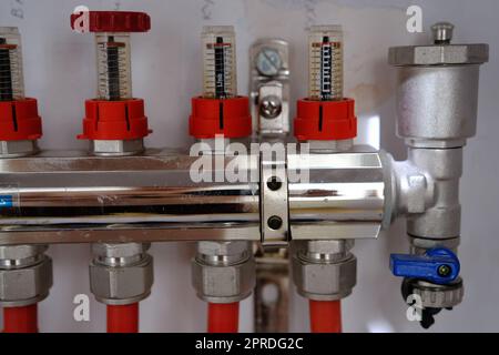 Verteilerventile für Heizanlagen für Fußbodenwärme und Wasserversorgung in einem Landhaus. Rohrsammler in einem Gebäude im Bau Stockfoto