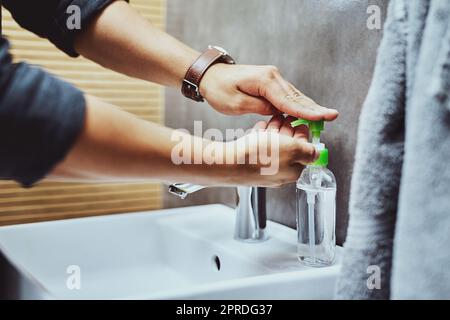 Was tun Sie, um die Ausbreitung zu stoppen. Ein unkenntlich Mann waschen seine Hände im Waschbecken im Bad. Stockfoto