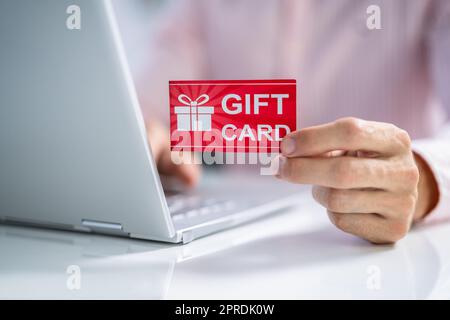 Mann Mit Roter Geschenkkarte Beim Tippen Stockfoto