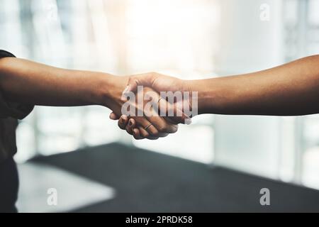 Ein weiterer erfolgreicher Deal wurde abgeschlossen. Nahaufnahme von zwei nicht erkennbaren Geschäftsfrauen, die sich an einem modernen Arbeitsplatz die Hände schüttelten. Stockfoto