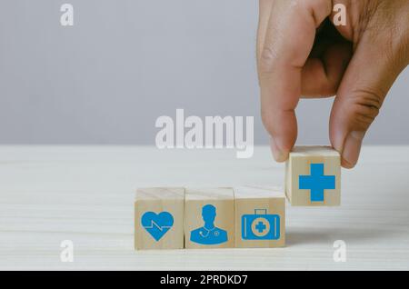 Hand hält Holzwürfel Block mit Versicherung Krankenwagen medizinischen Symbol auf dem Hintergrund und Platz kopieren. Stockfoto