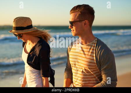 Sommer, die Jahreszeit zum Verlieben. n liebevolles junges Paar, das gemeinsam am Strand spazieren geht. Stockfoto