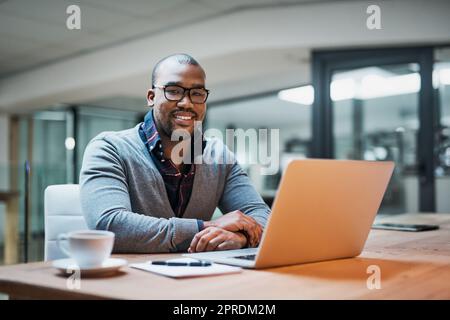 Gutes Geschäft hält ein Lächeln auf seinem Gesicht. Porträt eines hübschen jungen Geschäftsmannes, der in seinem Büro arbeitet. Stockfoto