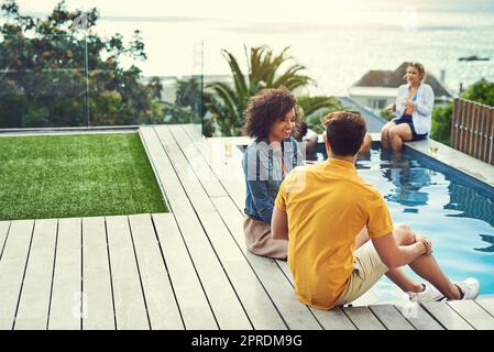 Hes ließ sie schließlich wissen, wie er sich fühlt. Eine Gruppe von Freunden, die Getränke trinken und sich im Urlaub am Pool amüsieren. Stockfoto