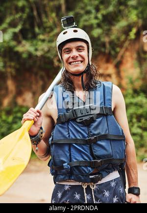 Das Leben ist ein Abenteuer, wage es. Ein abenteuerlustiger junger Mann, der einen Helm mit einer Action-Kamera trägt. Stockfoto