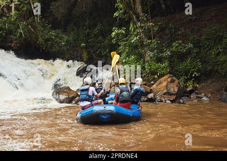 Das Leben hat keine Grenzen, außer den, die Sie machen. Eine Gruppe von Freunden auf dem Fluss Rafting an einem sonnigen Tag. Stockfoto