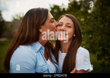 Sie machen mich so stolz. Eine junge Frau küsst ihre junge Tochter auf die Wange. Stockfoto