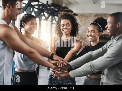 Eine Gruppe junger Menschen, die sich in einer Turnhalle solidarisch zusammenschließen. Stockfoto