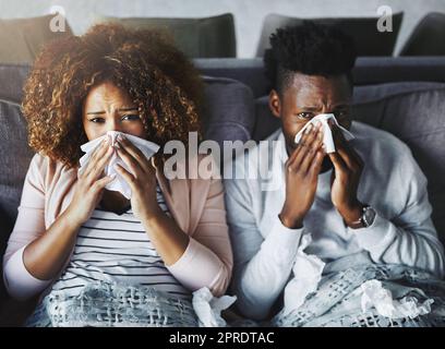 Portrait eines kranken Paares, das zu Hause gemeinsam an Grippe, Korona oder Sinus leidet, sich unwohl und schwach fühlt. Freundin und Freund in Quarantäne, sich von einem Virus erholen und sich drinnen ausruhen Stockfoto