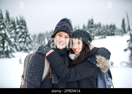 Winterliebe ist viel besser als Sommerliebe. Ein glückliches junges Paar genießt sich, während es draußen im Schnee ist. Stockfoto