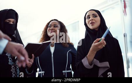 Planung erhöht Ihre Erfolgschancen. Aufnahme einer Gruppe verschiedener Geschäftskollegen, die in ihrem Büro an einem Whiteboard arbeiten. Stockfoto