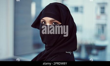 Alles auf Produktivität eingestellt. Zugeschnittenes Porträt einer arabischen Geschäftsfrau in einer Burka, die in ihrem Büro steht. Stockfoto