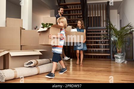 Jeder hilft aus. Eine junge Familie an ihrem bewegenden Tag. Stockfoto