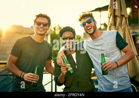 Kalte mit der Crew. Eine Gruppe junger Freunde, die draußen herumhängen und gemeinsam im Freien trinken. Stockfoto