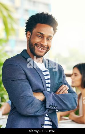 Hes führte sein Team mit großer Expertise an. Porträt eines hübschen jungen Geschäftsmannes, der draußen mit seinen Kollegen im Hintergrund steht. Stockfoto