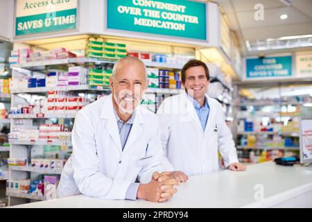 Waren mehr als glücklich, Ihre Bedürfnisse im Gesundheitswesen zu erfüllen. Porträt zweier Apotheker, die in einem Chemiker arbeiten. Stockfoto