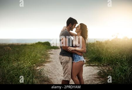 Nichts sagt Sommerromantik wie ein Tag am Strand. Ein junges Paar, das einen romantischen Tag am Strand verbringt. Stockfoto