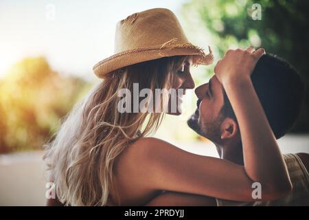 Genießen Sie jeden Moment. Ein liebevolles junges Paar, das einen intimen Moment draußen auf ihrem Balkon teilt. Stockfoto