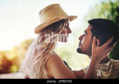 Ich könnte mich in diesen Augen verlaufen... ein liebevolles junges Paar, das einen intimen Moment draußen auf ihrem Balkon teilt. Stockfoto